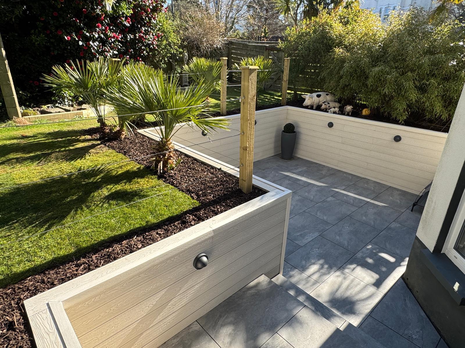 Composite planters Bournemouth with grey porcelain patio and wall lights – Marshall Landscapes